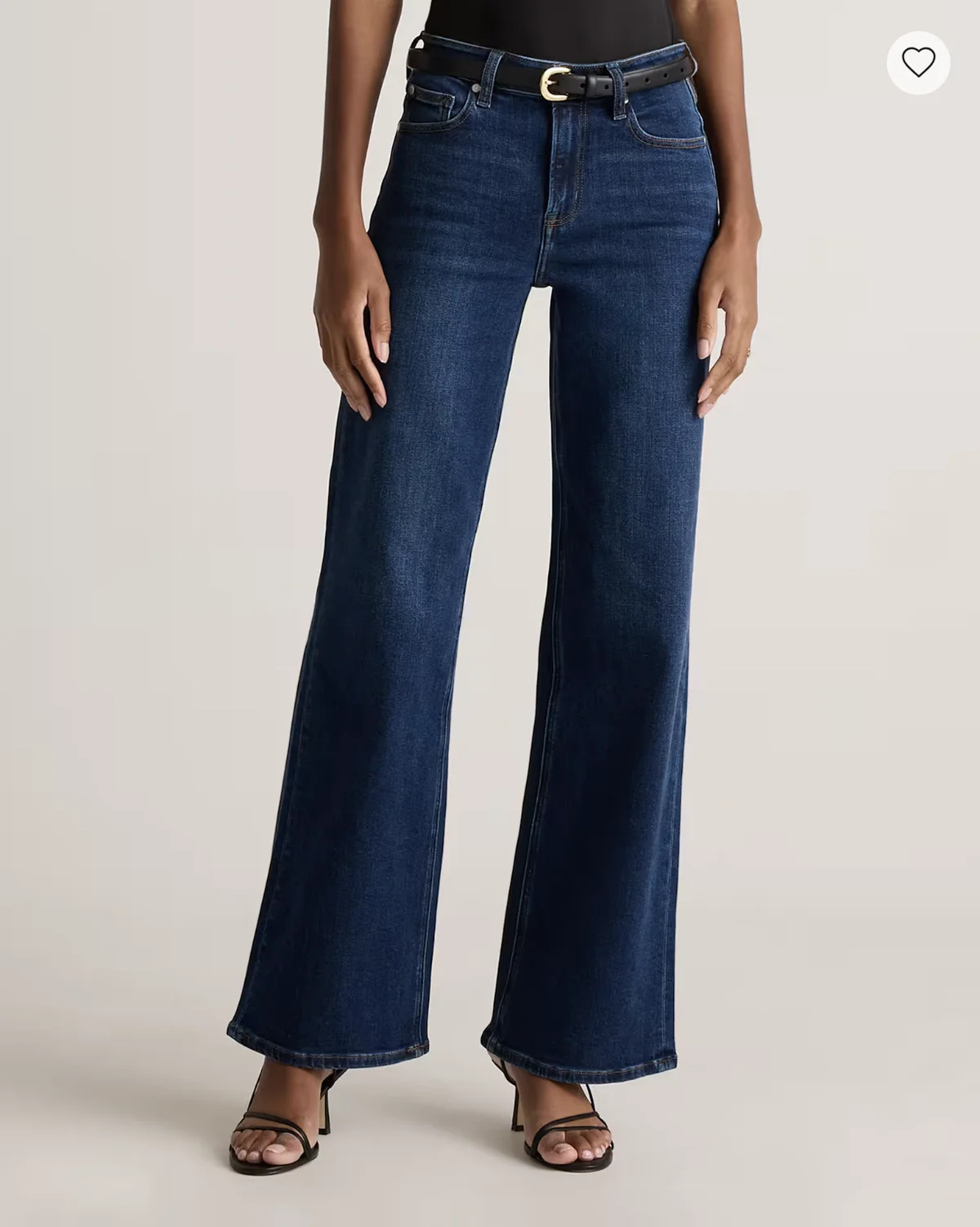 Model in dark wide-leg high-waist jeans with black belt and heels