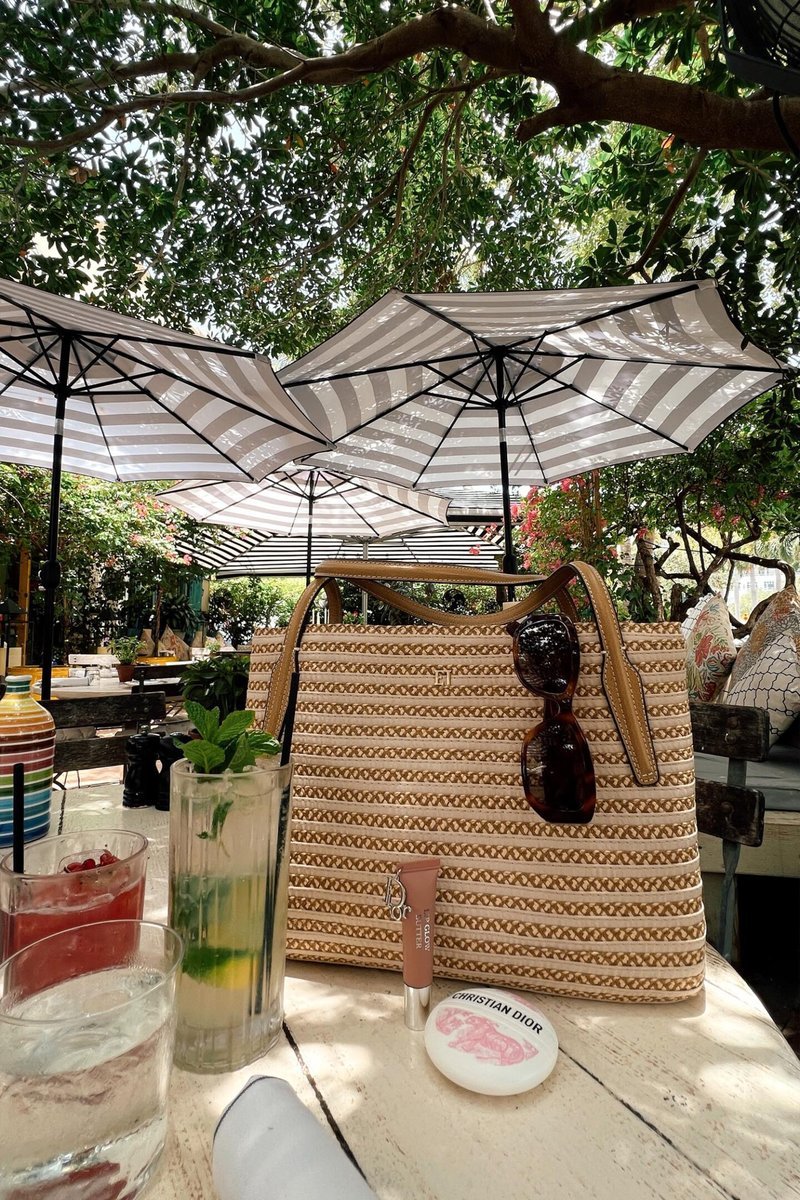 Beauty products and drinks on a café table outdoors
