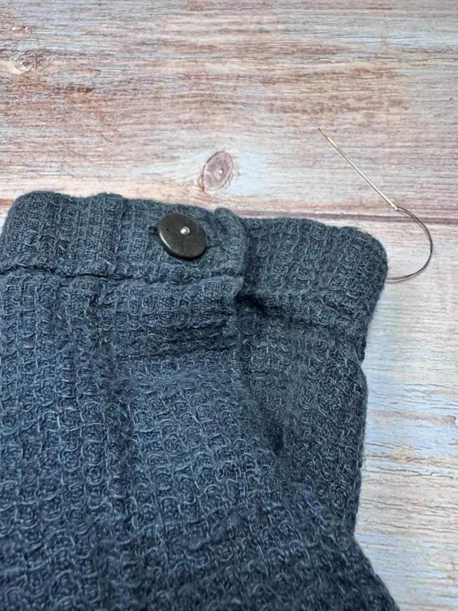 Sewing a replacement button onto a garment cuff