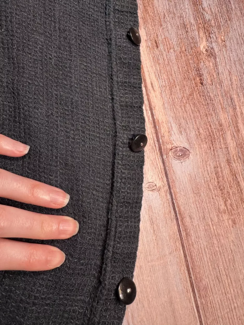 A shirt's button band with one loose button re-sewn