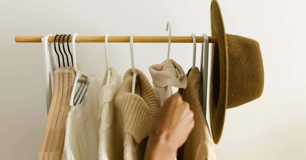 Earthy neutral-toned clothing hanging on a wooden rack