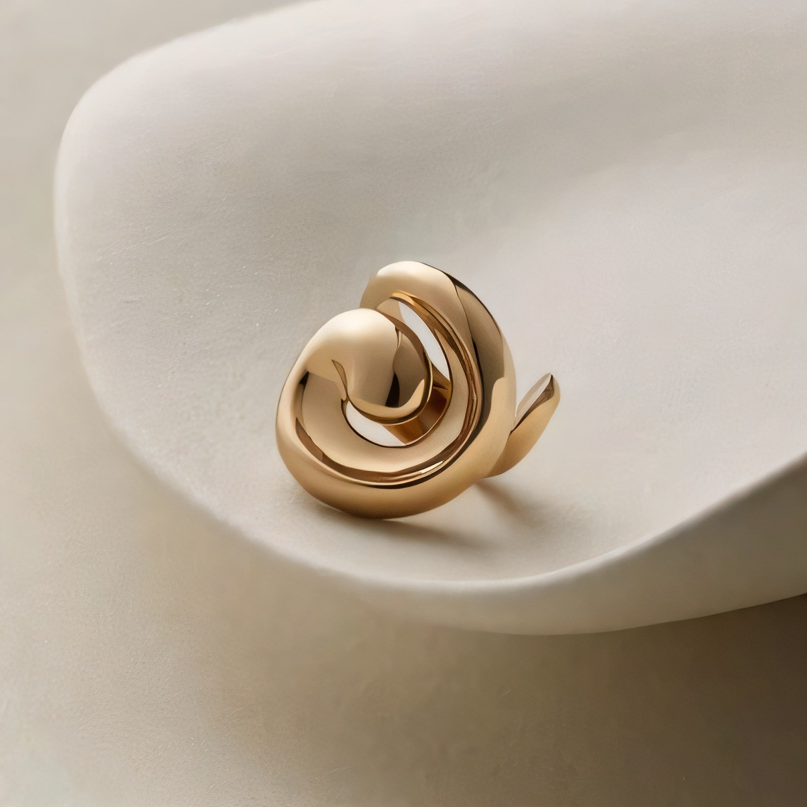 Gold spiral ring on a white ceramic dish