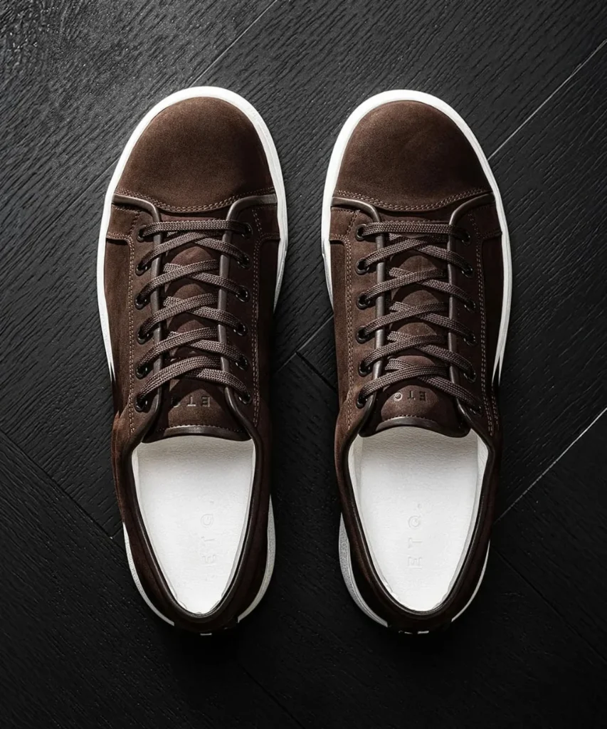 Brown suede low-top sneaker with white sole on neutral background