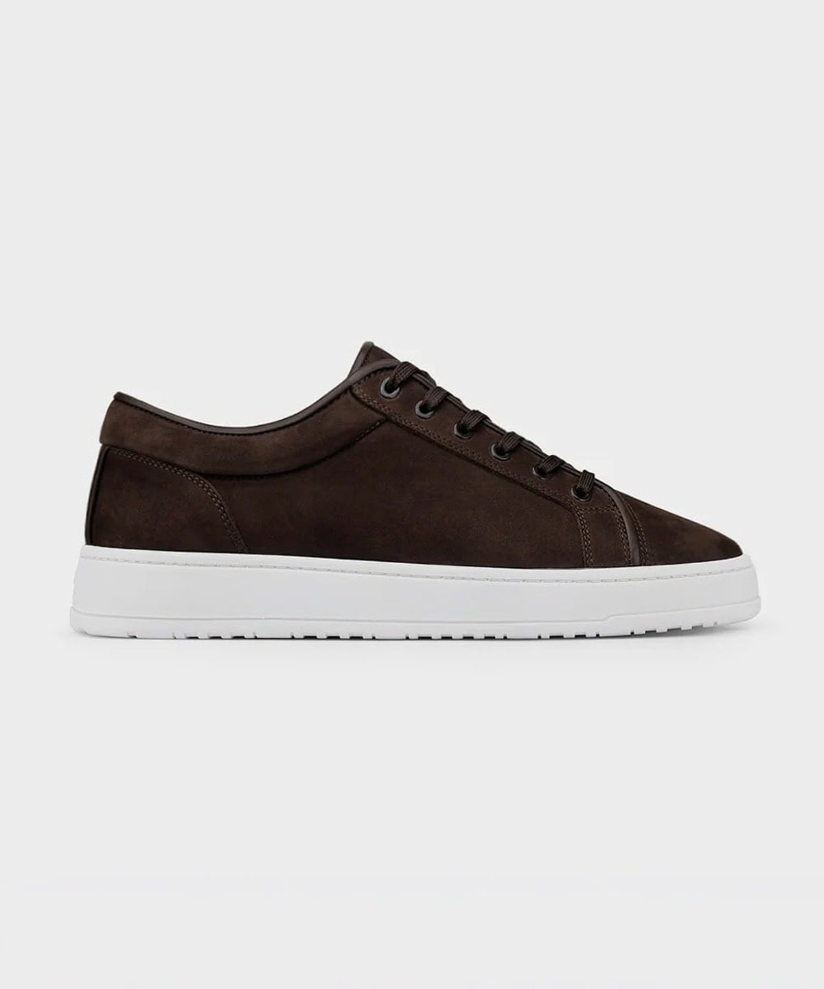 Brown suede low-top sneakers photographed from above on dark wood